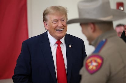 Republican presidential candidate and former U.S. President Donald Trump laughs with a DPS trooper during a Thanksgiving luncheon in Edinburg, Texas. November 19, 2023.