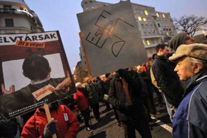 Un manifestante antigubernamental sostiene una pancarta con la esvástica hecha con las letras de Fidesz en Budapest.