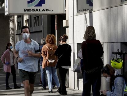 Ciudadanos haciendo cola para hacerse test del coronavirus en un laboratorio privado de Madrid, este miércoles.