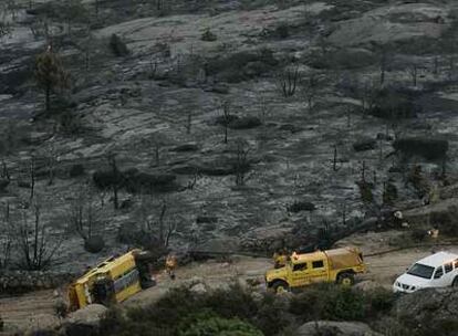 Un <i>hummer</i> (todoterreno de grandes dimensiones) volcado en mitad de la zona arrasada por el fuego.