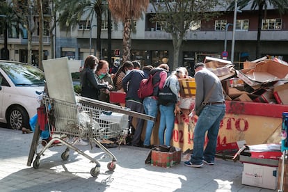 Ciudadanos recogen zapatos y otros objetos de un contenedor el pasado 6 de octubre en Barcelona.