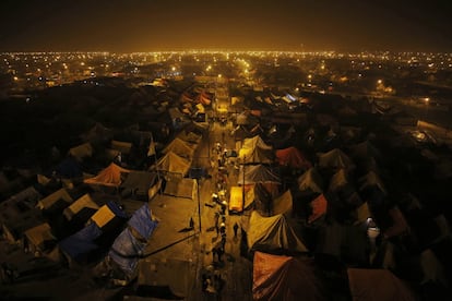 Devotos hindúes caminan de madrugada en Sangam, en la confluencia de los ríos Ganges y Yamuna, durante la tradicional feria anual "Magh Mela" en Allahabad, India.