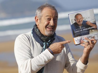 El cocinero Karlos Argui&ntilde;ano posa junto a su &uacute;ltimo libro con la playa de Zarautz al fondo.