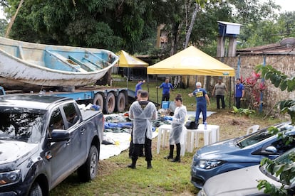 Oficiales de policía inspeccionan objetos retirados del bote.