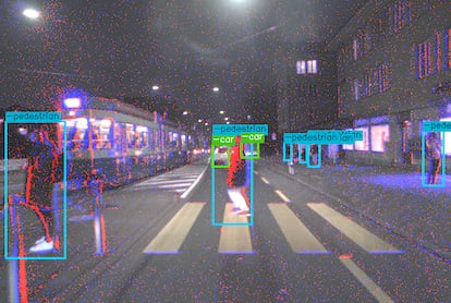 La imagen muestra tanto la información de la cámara a color como los eventos (puntos azules y rojos) de la de eventos; Los cuadros delimitadores muestran la detección de peatones por parte del  algoritmo.