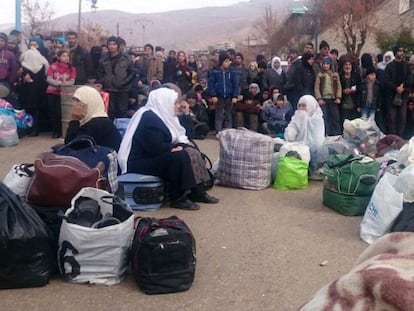 Um grupo de sírios espera a chegada da ajuda humanitária em Madaya.