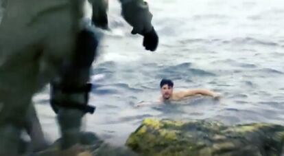 A man reaches the Spanish shore after swimming in from Moroccan territory.