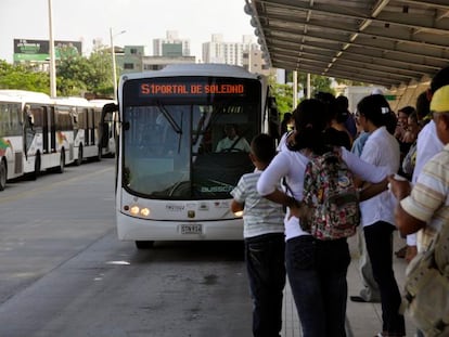 Personas esperan en un andén para abordar el Transmetro en Barranquilla (Colombia).