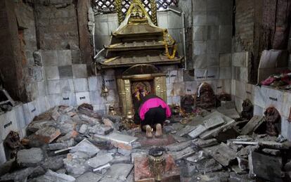 Una nepalí hindú reza en el templo de Indrayanim, en Katmandú, dañado por el terremoto.