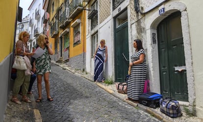 Turistas esperan para entrar en el apartamento que han alquilado en el barrio histórico de Santa Catarina, en Lisboa, el pasado 10 de julio.