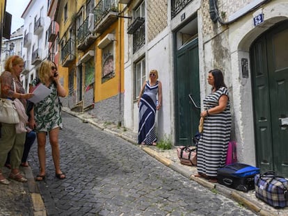 Turistas esperan para entrar en el apartamento que han alquilado en el barrio histórico de Santa Catarina, en Lisboa, el pasado 10 de julio.