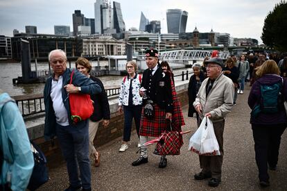 La gente hace cola frente a los rascacielos de la ciudad de Londres, mientras espera para despedir el féretro de Isabel II, este juves.