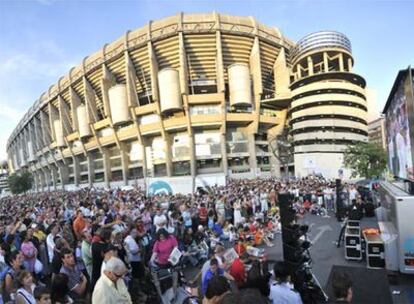 Miles de aficionados siguen la presentación del portugués en una pantalla fuera del Bernabéu.