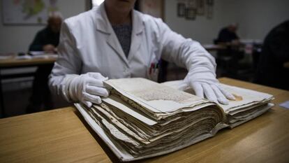 Una trabajadora del Archivo Histórico Diocesano de Santiago consulta datos en un manuscrito.