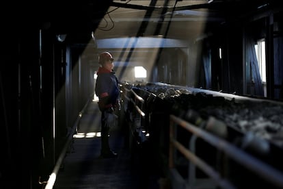 Una empleada inspecciona la cinta transportadora de carbón en una fábrica, en Yuncheng (China).