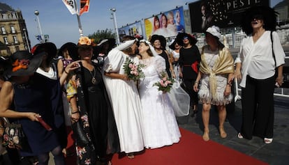 Un grupo de trabajadoras de un centro comercial vestidas de época, que celebran la jubilación de dos de ellas (vestidas de novias), pasan por la alfombra roja de la 65 edición del Festival Internacional de Cine San Sebastián.