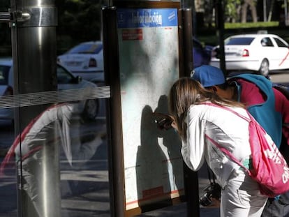 Una pareja de turistas miran un plano del metro de Madrid.