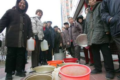 Vecinos de Harbin hacen cola para recibir agua de los equipos de emergencia.