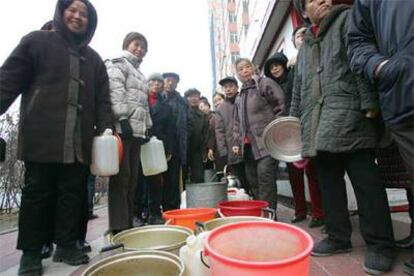 Vecinos de Harbin hacen cola para recibir agua de los equipos de emergencia.