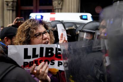Una manifestante sujeta un cartel en el que se puede leer 'Libertad presos políticos' durante la protesta por la detención de Carles Puigdemont en el centro de Barcelona, el 25 de marzo de 2018.