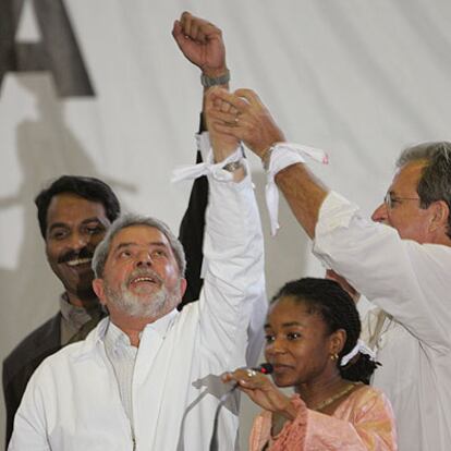 Lula (centro) y otros oradores en Porto Alegre exhiben el brazalete blanco que simboliza la lucha contra la pobreza.