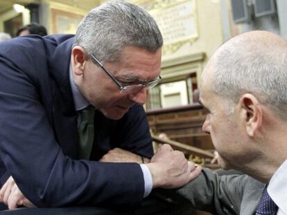 El ministro de Justicia, Alberto Ruiz-Gallardón, conversa con el diputado socialista Manuel Chaves durante el pleno del Congreso.