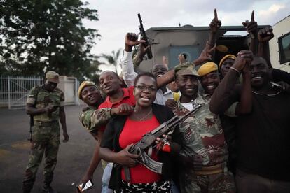 Un grupo de residentes y soldados celebran la renuncia del presidente de Zimbabwe, en Harare.