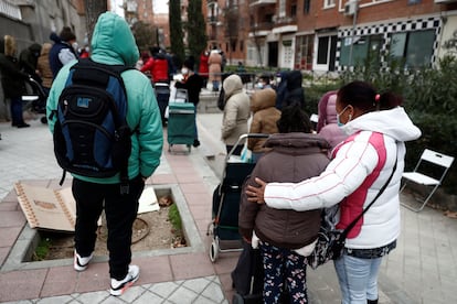 Varias personas esperan su turno para recibir alimentos, en la plaza de San Amaro en Madrid.