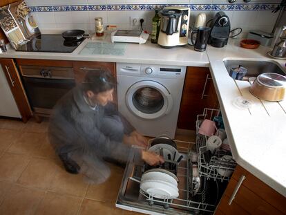 Un hombre recoge el lavavajillas.