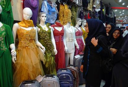 Varias mujeres miran vestidos de colores en un mercadillo de Shiraz, en Irán.