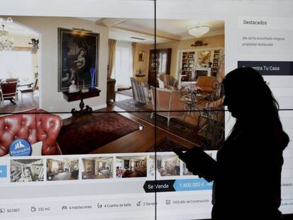 Una mujer contempla el anuncio de una vivienda en una web inmobiliaria.
