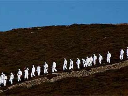 Un grupo de soldados se encamina a limpiar chapapote en el cabo Vilán, en el noroeste de la costa gallega.