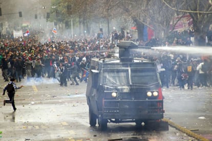 La policía intenta dispersar con cañones de agua una de las marchas celebradas ayer en Santiago.