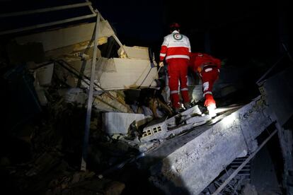 Personal de rescate trabajan entre los escombros de un edificio en Sarpol-e Zahab (Irán).