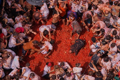 Revelers throw tomatoes at each other during the annual "Tomatina" tomato fight fiesta, in the village of Bunol near Valencia, Spain, Wednesday, Aug. 27, 2025. (AP Photo/Alberto Saiz)