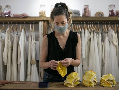 Ruth Fernández, propietària d'una botiga de vestits de núvia, s'ha reinventat fent mascaretes de tela al seu taller.