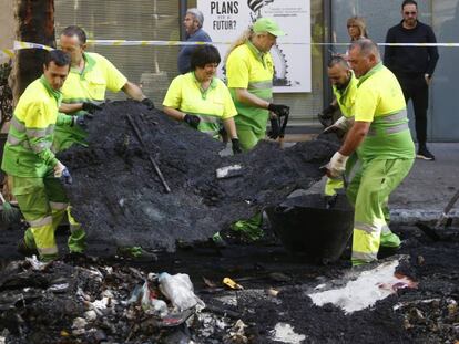 Operaris retiren les restes de contenidors cremats.