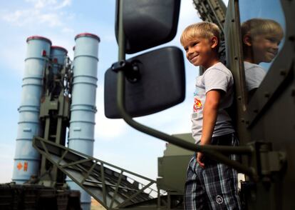 A boy stands on the S-300 air defence mobile missile system during the International Army Games 2016 at the Ashuluk military polygon outside Astrakhan, Russia, August 7, 2016. REUTERS/Maxim Shemetov