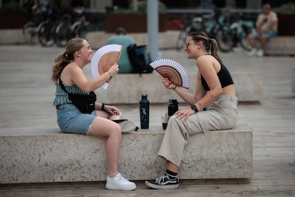 Dos jóvenes se abanican en Valencia, este lunes.