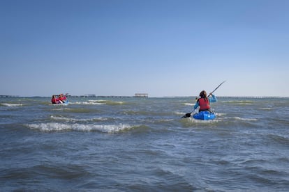 Kayak en la bahía dels Alfacs y, al fondo, varias bateas.