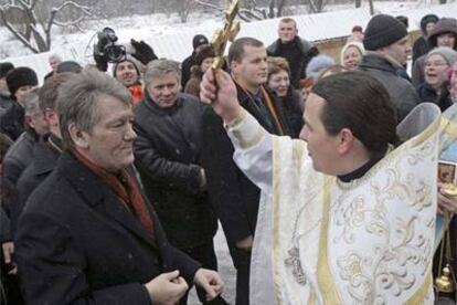 Un sacerdote ortodoxo bendice a Víktor Yúshenko durante la celebración de la Epifanía, el martes en Kiev.