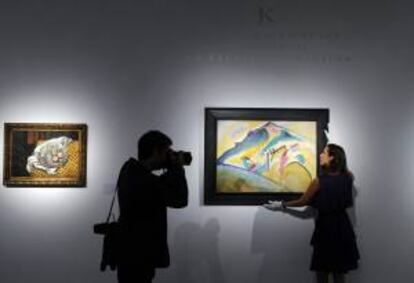 Una empleada de la casa de subastas británica Christie's posa para los medios junto a una obra. EFE/Archivo