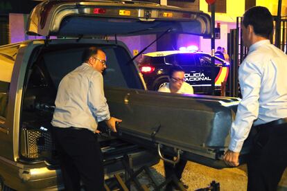 Trabajadores de la funeraria trasladan el cadáver de la mujer asesinada en Granada.