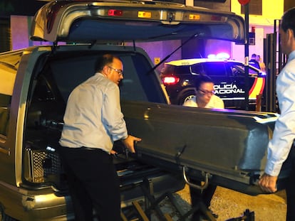 Trabajadores de la funeraria trasladan el cadáver de la mujer asesinada en Granada.