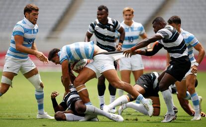 Semifinal de rugby 7 entre las selecciones de Argentina y Fiji. Argentina ha perdido con Fiyi y luchará por el bronce con Gran Bretaña. En la imagen, el argentino Lucio Cinti Luna es agarrado por un rival durante el partido.