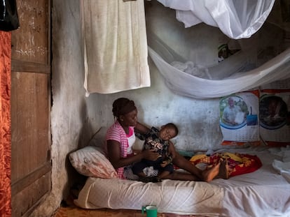 Una adolescente, beneficiaria del proyecto 'Derecho a ser niña', de Save the Children, posa junto a su hijo en su casa del distrito de Pujehun (Sierra Leona).