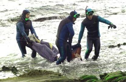 Submarinistas de la Guardia Civil cargan el cadáver de uno de los inmigrantes ahogados en Tarifa.