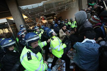 Policías antidisturbios y estudiantes británicos se enfrentan a las puertas del edificio Milbank, sede del Partido Conservador.