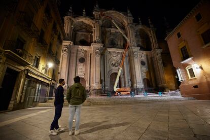 Operarios revisan, en la noche del viernes, la fachada de la catedral de Granada tras desprenderse algunos fragmentos.