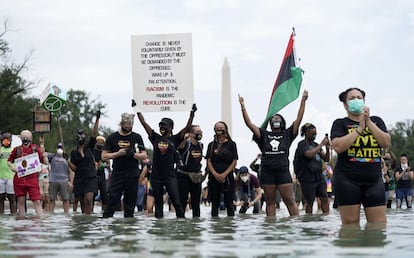 Los asistentes se paran en la piscina reflectante cerca del Lincoln Memorial durante la marcha en Washington.